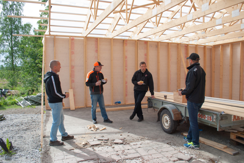 Olli, Staffan, Simon och Gabriel står och dricker kaffe och pratar i garaget som håller på att byggas